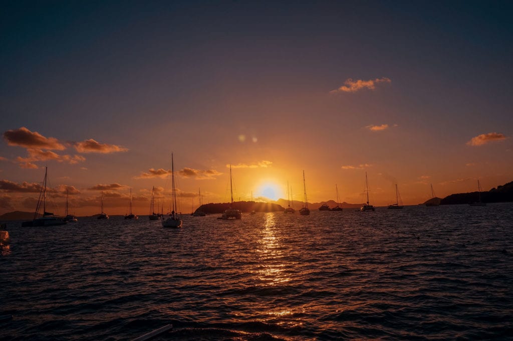 Sonnenuntergang in der Karibik, diverse Segelyachten ankern in der Bucht