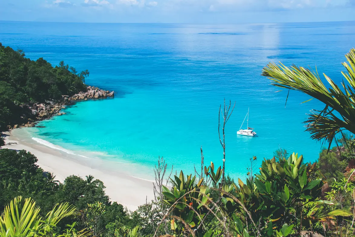 Segeln am Strand in den Seychellen in klarem, hellblauem Wasser