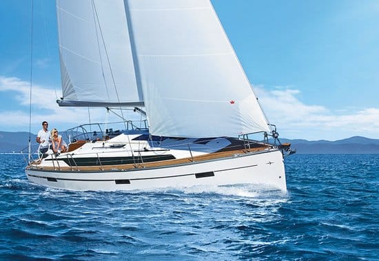 Ein weißes Segelboot mit zwei Personen an Bord segelt auf einem strahlend blauen Meer unter klarem Himmel. Das Boot, Teil eines Yachtcharter-Erlebnisses, hat seine Segel voll gesetzt und im Hintergrund ist die Küstenlinie sichtbar, mit Bergen, die sich entlang des Horizonts erstrecken.